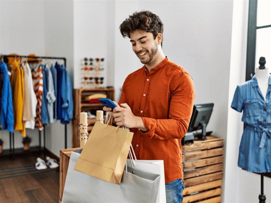 Shopper in a clothing store checking their phone