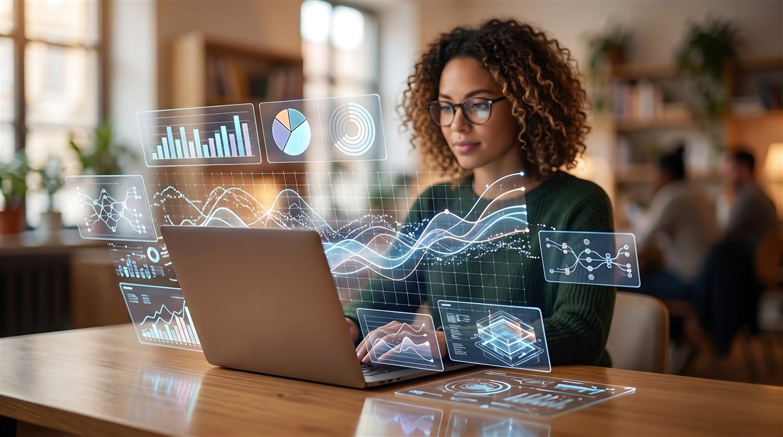 A business analyst reviewing charts and dashboards on a laptop