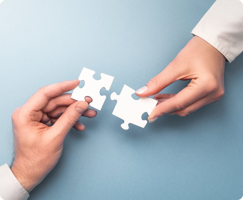 Hands joining two puzzle pieces