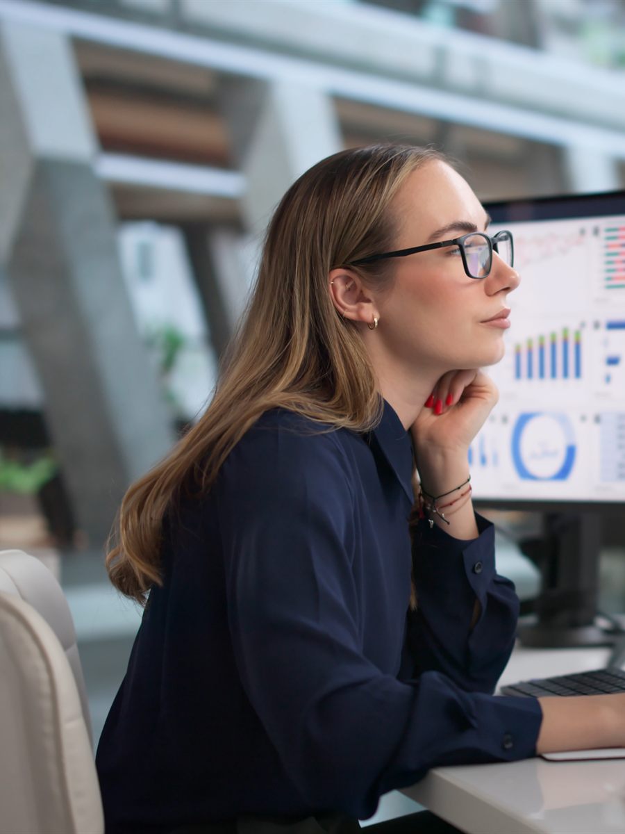 A data leader reviewing analytics dashboards on a multi-screen workstation