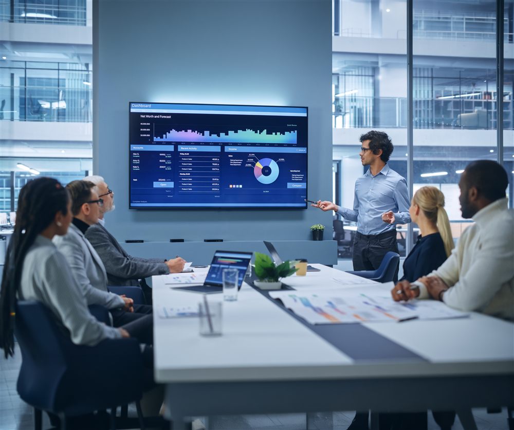 A data leader presenting a platform dashboard to colleagues in a meeting room